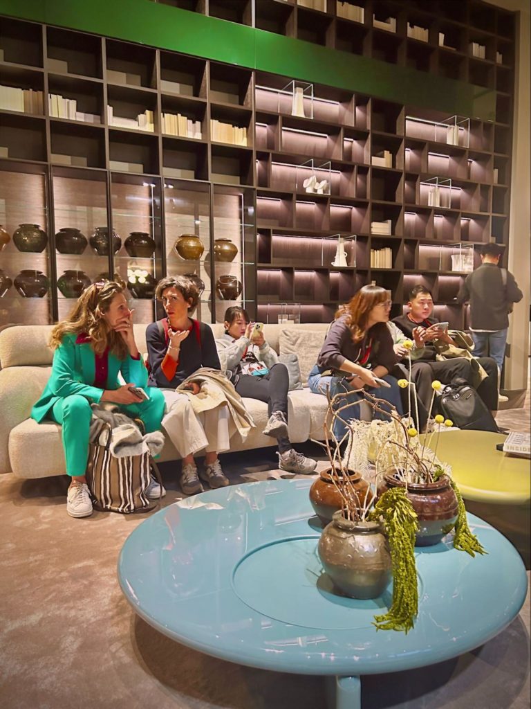 Geglazuurde Chinese potten op een tafel en in de boekenkasten op Salone Del Mobile Milano 2024.